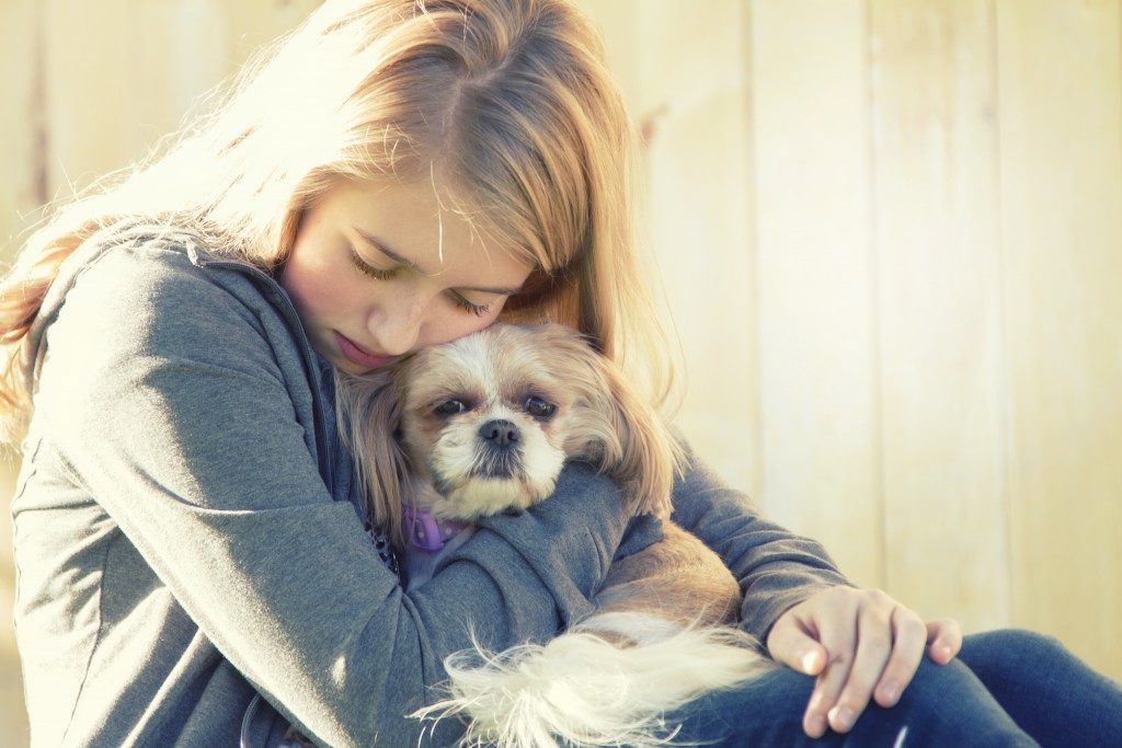 teenager hugging her pet dog