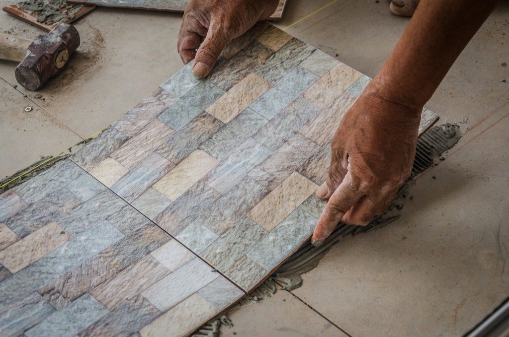 man installing stone flooring