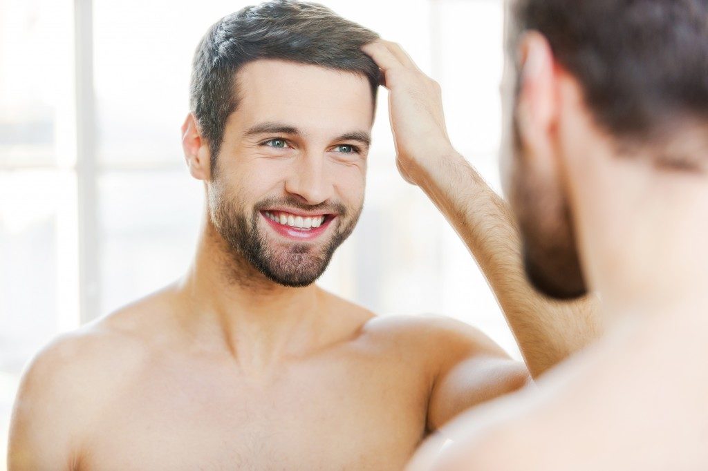 man smiling looking at the mirror