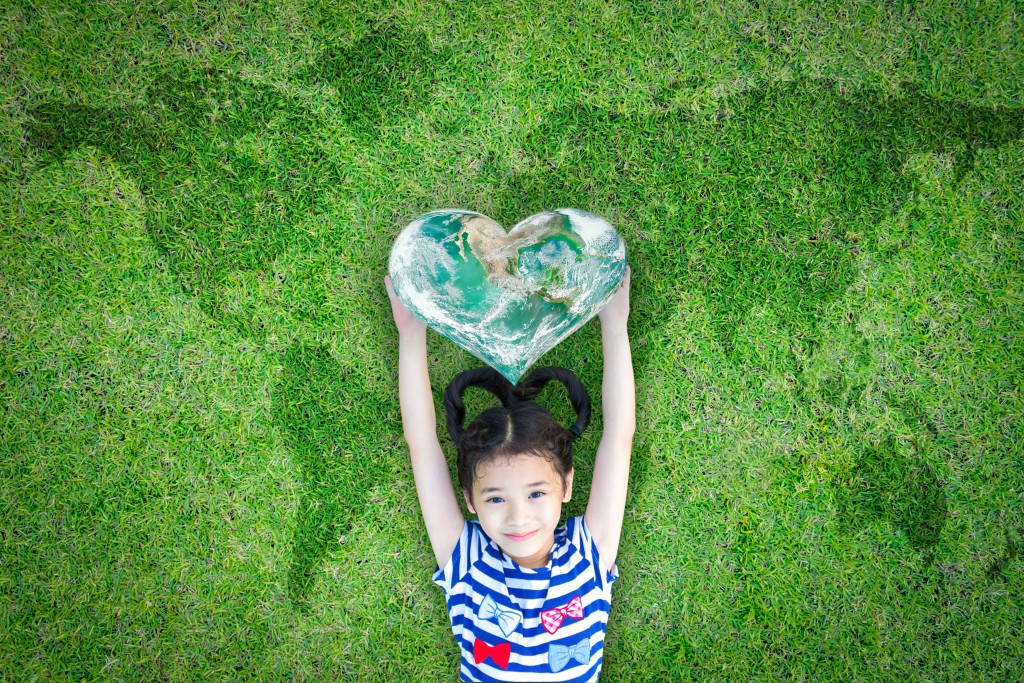 child holding a heart shaped earth