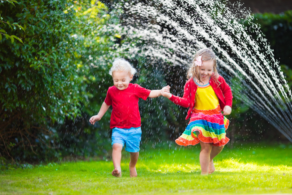 kids playing with the sprinkler