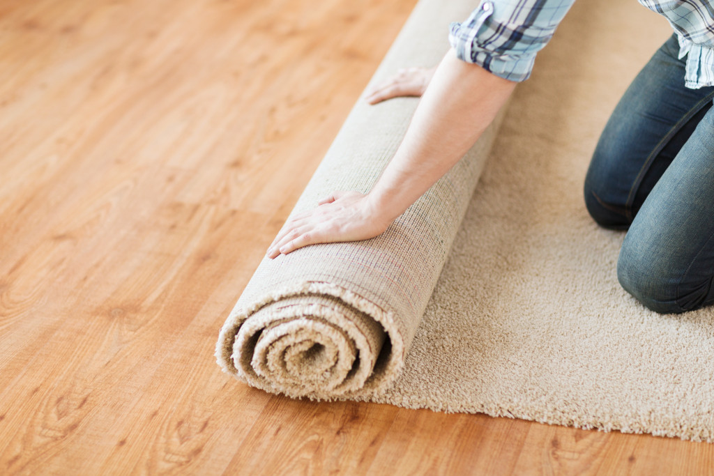 person rolling carpet on floor