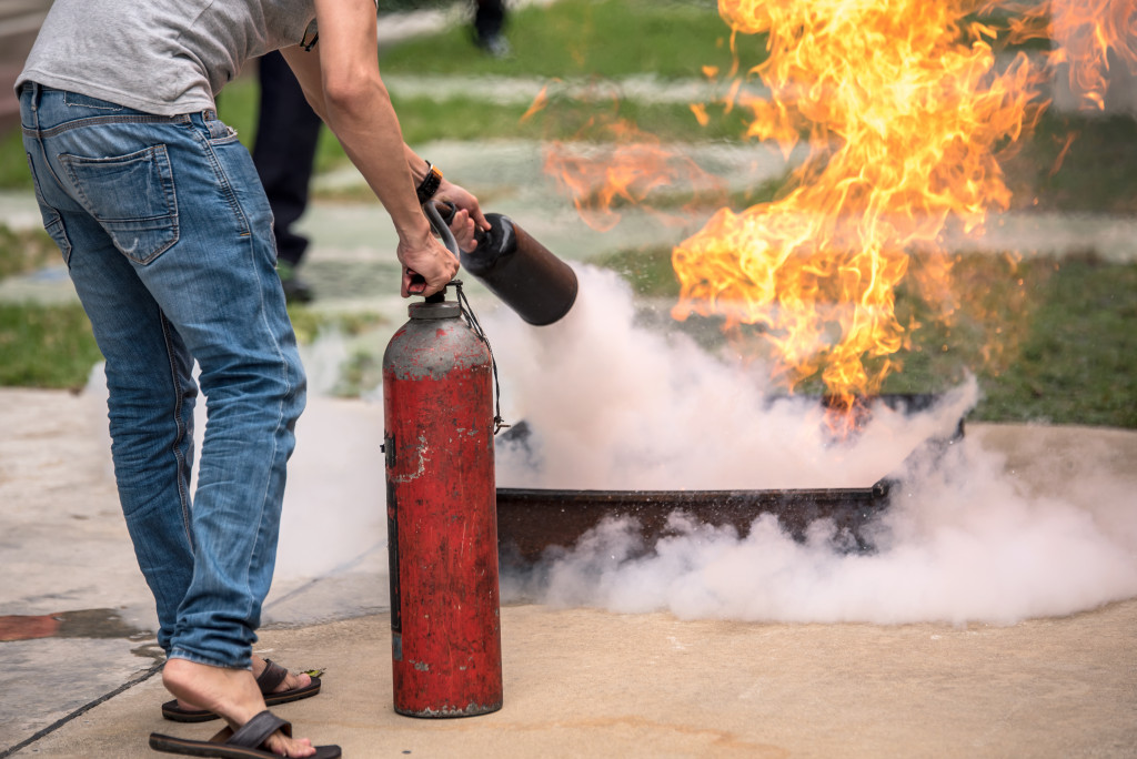 A man using fire extinguisher to stop fire
