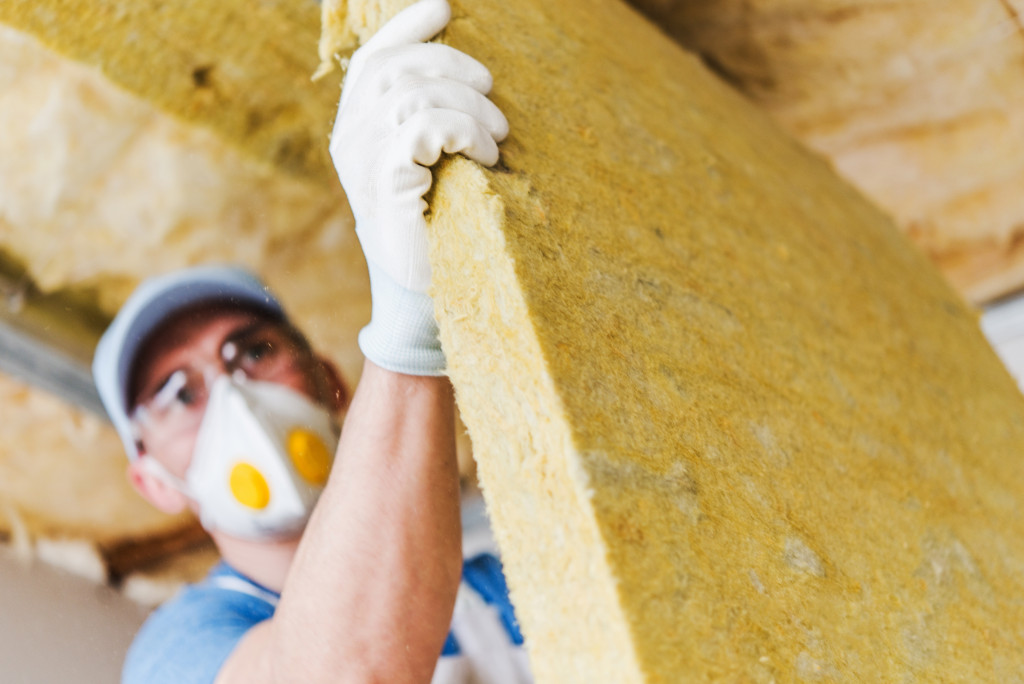 a male worker installing insulation