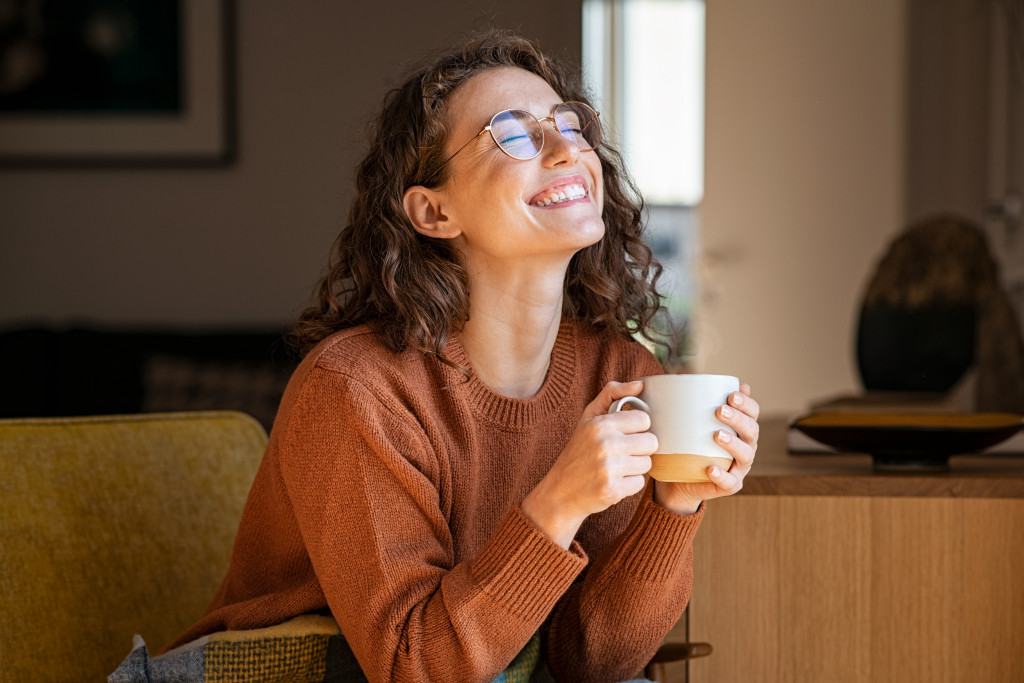 A young woman relaxing while drinking coffee at home