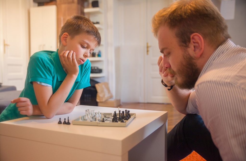 dad playing chess with his son