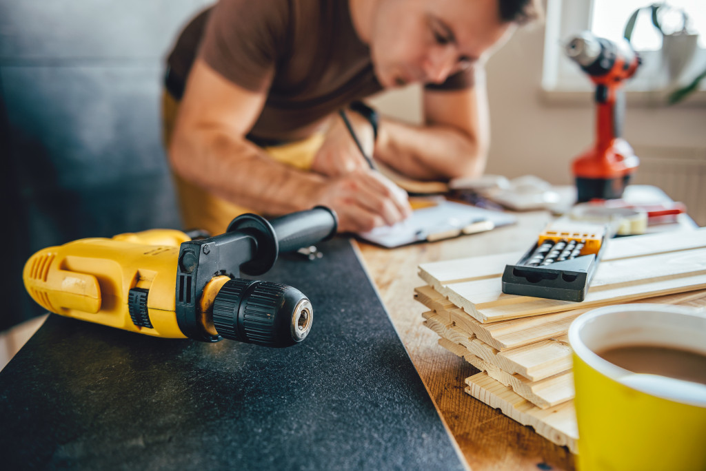 Professional working on renovating a home with tools and materials in front of him.