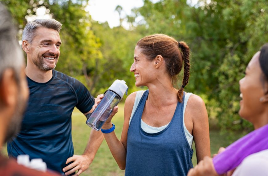 middle aged people smiling and talking after a workout session outdoors