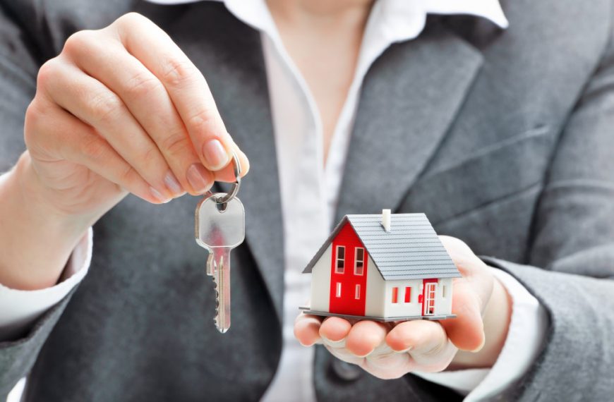 An agent holding a small house and house keys