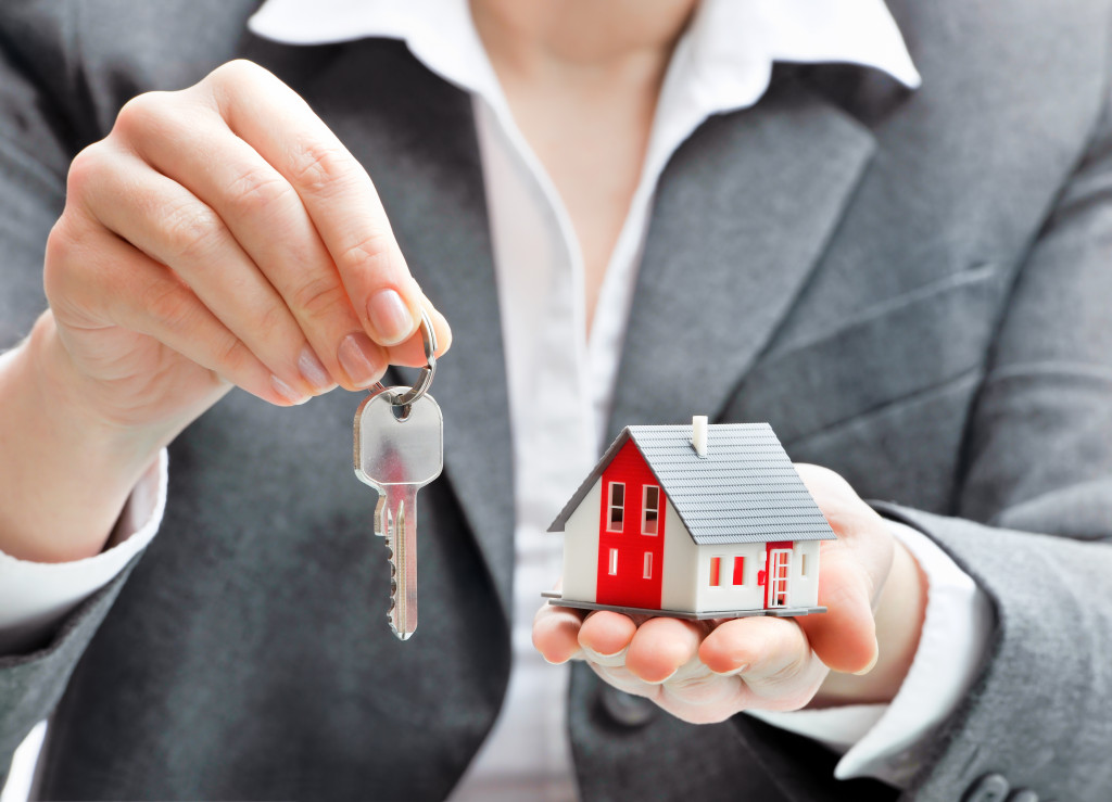 An agent holding a small house and house keys