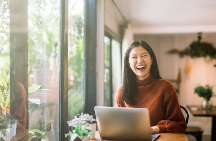 happy woman using laptop at the restaurant