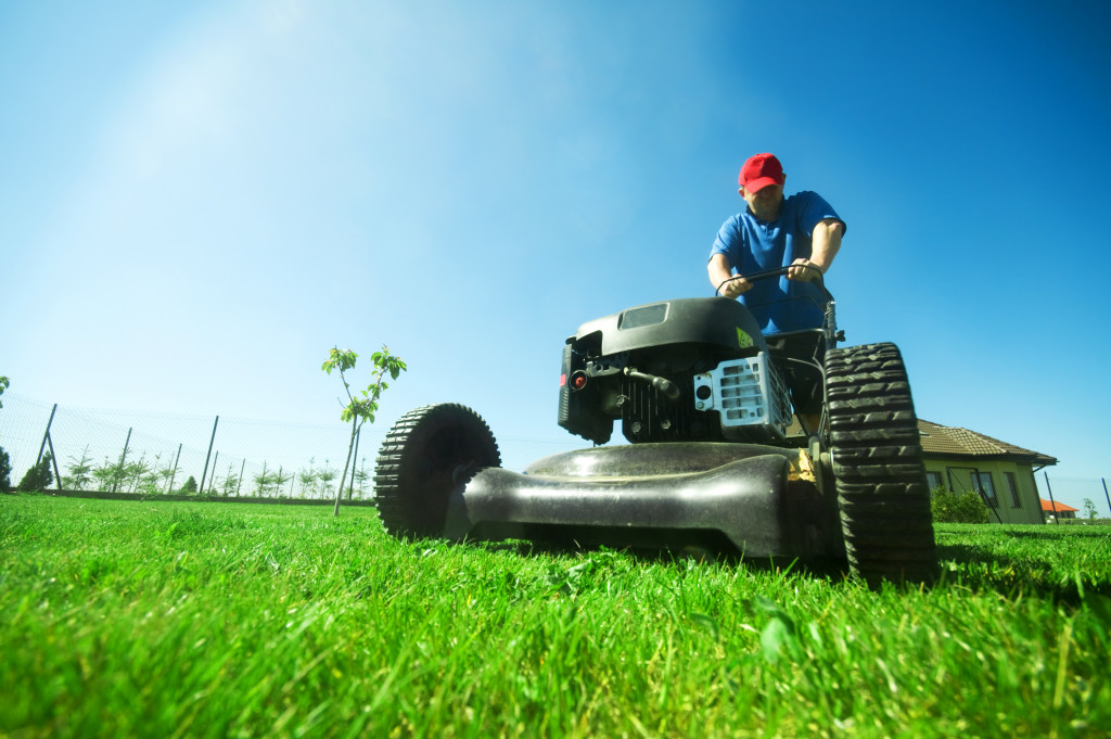 a man trimming the grass in his yard