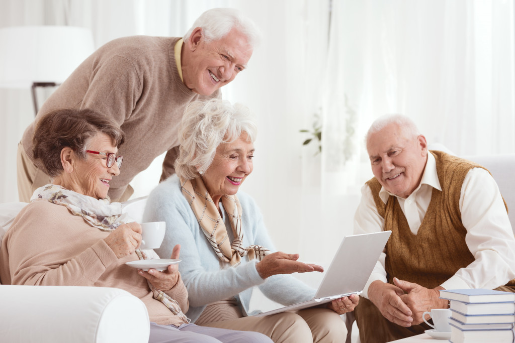 Senior adults using a computer at a sitting room.