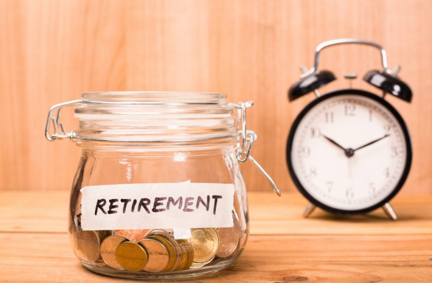 early retirement budget in glass jar next to alarm clock