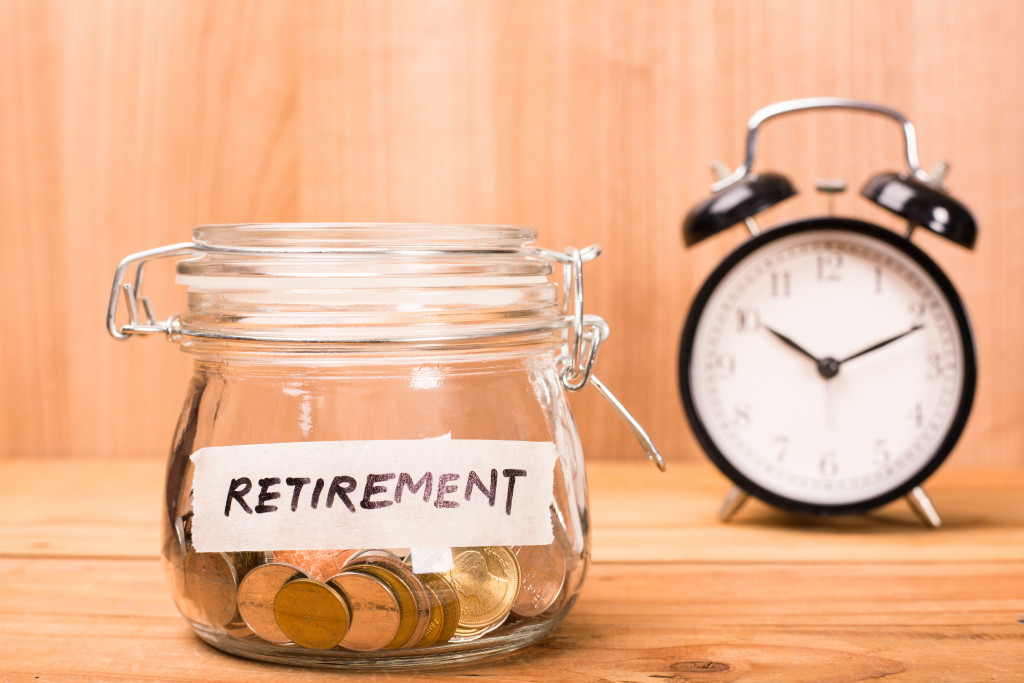early retirement budget in glass jar next to alarm clock