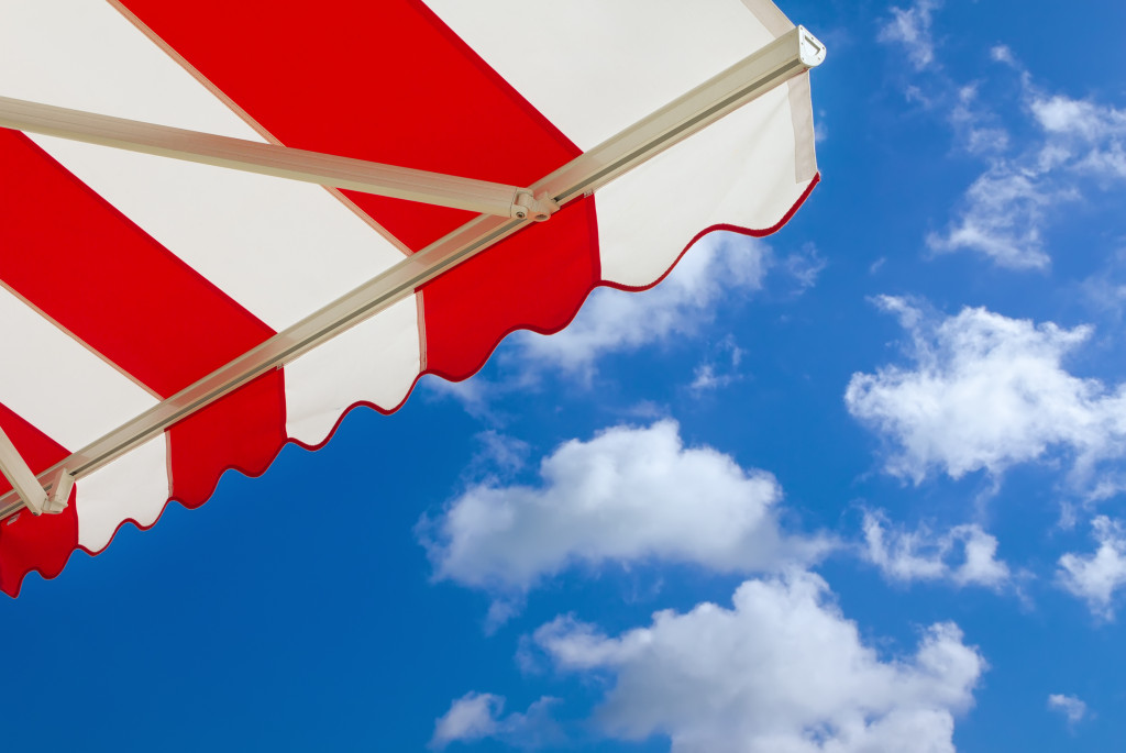 A red and white awning under blue skies