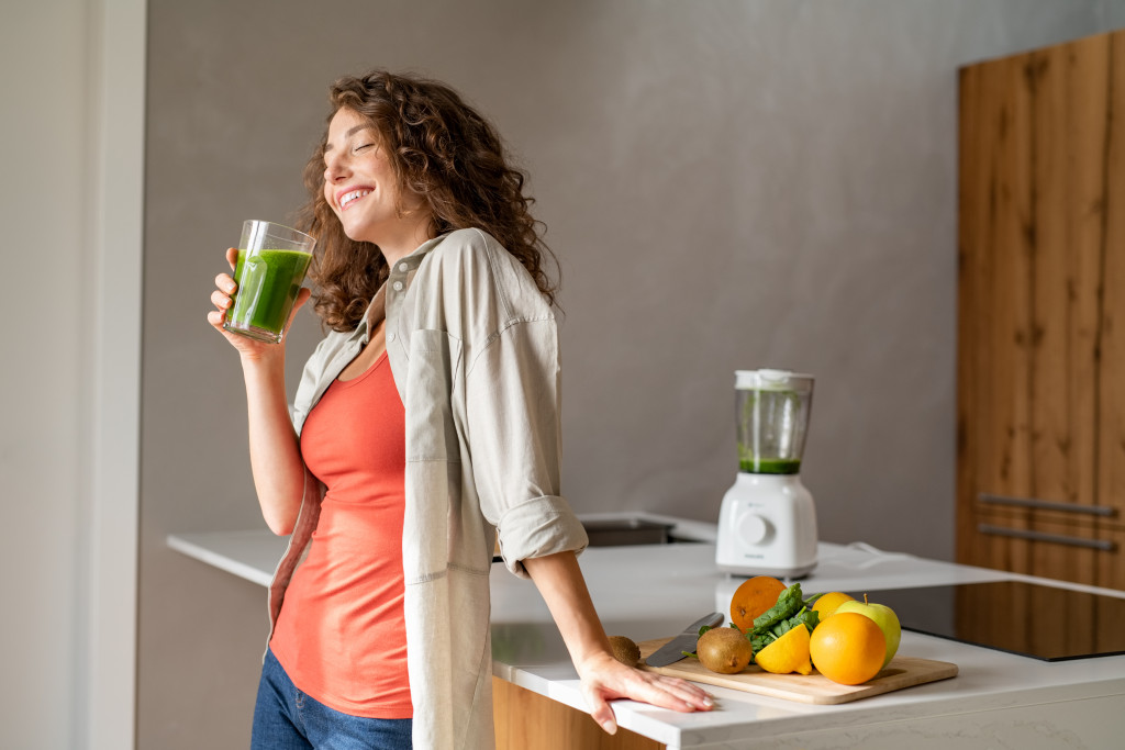 woman holding glass of detox juice