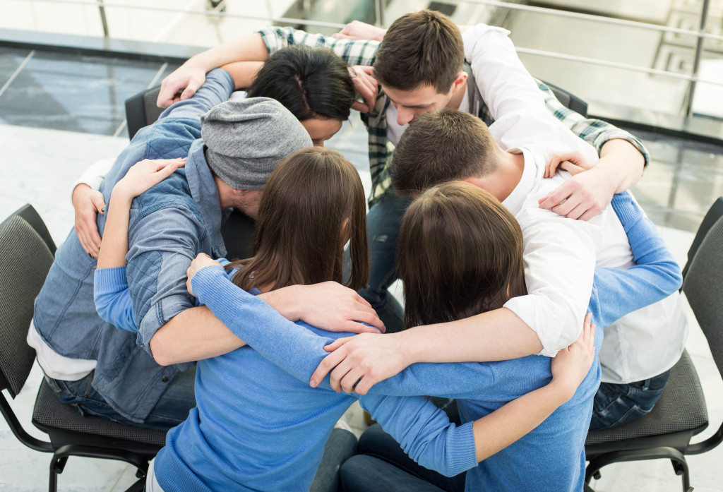 A group of adults hugging each other