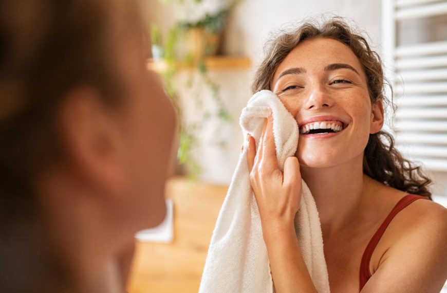 a woman wiping her face with towel